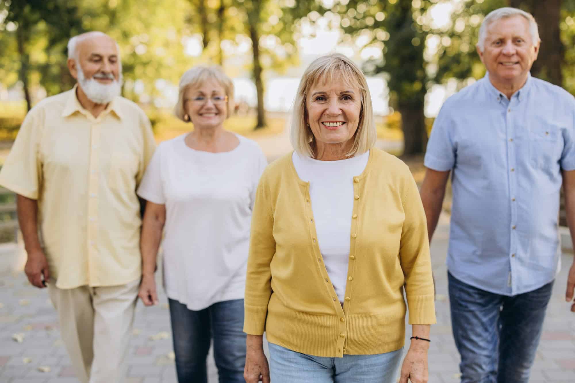 Senior blonde woman against the background of group of old people in park